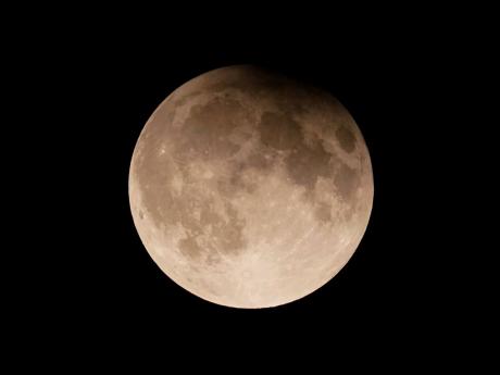 A supermoon with a partial lunar eclipse rises over Lake Michigan in Chicago.
