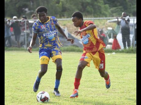 St Elizabeth High School’s Henry Johnson (left) tries to win the ball off Cornwall Colleges Mekhi Foster during their Ben Francis Cup quarterfinal at the Llandilo Community Centre in Westmoreland on Thursday.