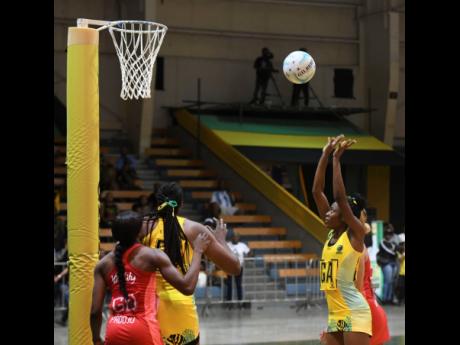 Credit: Antoine Lodge Sunshine Girls goal attack, Shanice Beckford (right) shoots during the final game of the Horizon Netball Series against the England Vitality Roses at the National Indoor Sports Centre last night. Watching closely are Sunshine Girls goal shooter, Romelda Ai