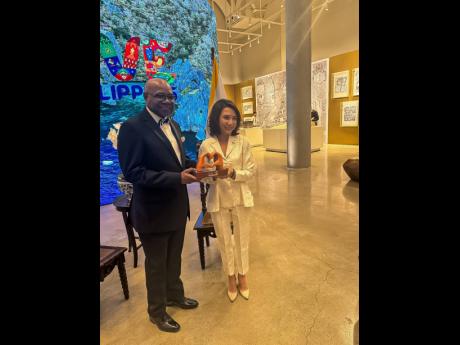 Minister of Tourism Edmund Bartlett (left) and the Secretary of Tourism for The Philippines, Christina Garcia-Frasco, shared lens time after he received his global Gusi Peace Prize last Wednesday at the Manila Metropolitan Theatre. 