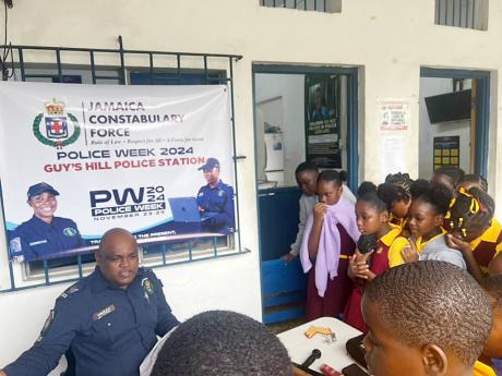 Credit: Rasbert Turner photo Sergeant Kenneth McTavish engaging a group of students from the Guy’s Hill Primary School.
