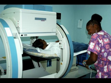 In this file photo, a nuclear medicine technologist is seen operating a gamma scintillation camera, which is used for medical imaging such as bone scans, lung scans, and thyroid scans.