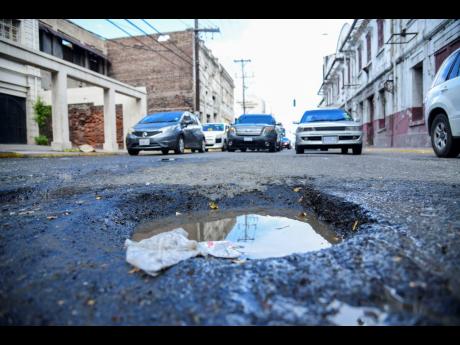 Motor vehicles heading in the direction of a pothole in the middle of the road on Port Royal Street in Kingston last August. 