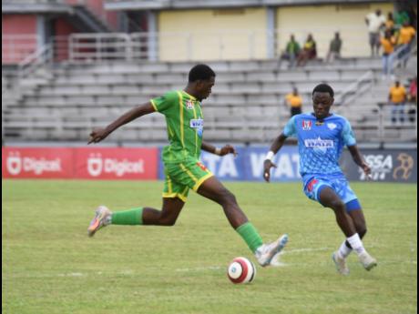 Credit: Ashley Anguin Ocho Rios High School’s Keanu Reid (left) tries to get past St Catherine High School’s Nathel Ellis during their Champions Cup quarterfinal at the Montego Bay Sports Complex on Friday November 22.
