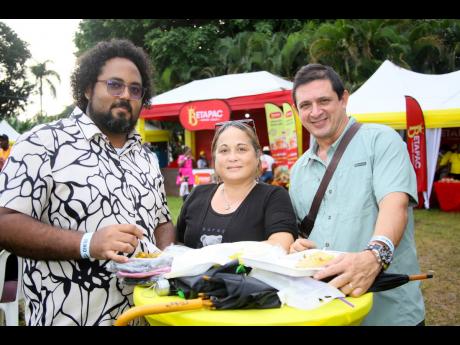 Credit: Nathaniel Stewart Cuban medical doctors working in Jamaica (from left), Alejandro Rodriguez, Arlenys Ramirez and Yoexis Leon, enjoy their very first curry festival in Jamaica.