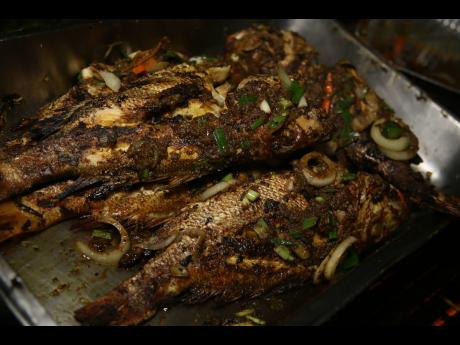 Credit: Roasted fish stuffed with curried goat was served by exhibitors from the popular Little Ochie Seafood Restaurant & Bar on the grounds of Devon House on Sunday.