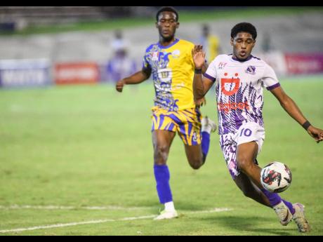 Kingston College’s Martrim Martin (right) in action against Hydel High’s  Alex Folkes during Tuesday’s Manning Cup semi-finals. 