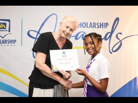 Credit: Contributed Jennifer Martin, JN Foundation board member, presents Xiomara Gordon, the 2024 JN Foundation PEP Scholar for Kingston, with her certificate during the JN Foundation scholarship award ceremony at The Jamaica Pegasus hotel in New Kingston recently.