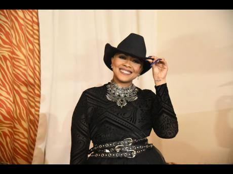 Laced in black with shining pops of silver from her extensive wardrobe, media presenter Deborah ‘Debbie’ Bissoon tips her hat to Mini’s Fashion in York Plaza, Half-Way Tree, St Andrew, for her wide-brimmed hat.