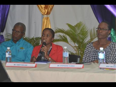 In this 2019 photo, Tamoy Sinclair, the now-outgoing parish disaster coordinator for St James, addresses a disaster preparedness forum at the St James Parish Library, along with Julian Robinson (left), senior public cleansing inspector at the National Soli