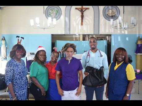 General practitioner at the Newport Medical Group, Dr Zavion Edwards (second right), presents a care package to a Greenwich Farm resident while staff of the Shipping Association of Jamaica (from left) Dionne Mason-Gordon, Jean Hinds-Bell, Toni-Ann Williams