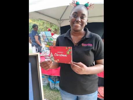 Aalihay Mahfood displaying one of Gzome Artistry’s locally made Christmas cards with a Jamaican theme.
