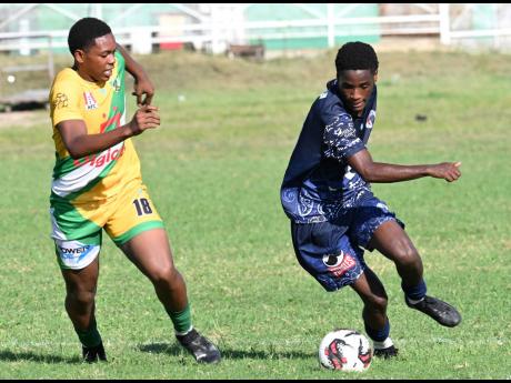 Jamaica College’s Nashordo Gibbs (right) dribbles past Excelsior High’s  Shamarie Chambers during an ISSA Manning Cup match at the Courtney Walsh Oval on October 9. Gibbs is a member of the Real Mona Football Club. 