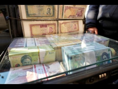 AP
Current and pre-revolution Iranian banknotes are displayed by a street money exchanger at Ferdowsi St in downtown Tehran, Iran, on Sunday, December 15, 2024. 