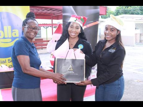 Dolla Financial Group Marketing Manager Tashoni Ellis (centre) and A-List Marketing Entertainment Group Managing Director Nackeria Smickle (right) celebrate the season of giving with Karen Haughton of the Salvation Army Nest Children’s Home during their 