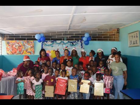 Staff from the Shipping Association of Jamaica treating pupils of the Marcus Garvey Basic School to refreshments and toys during its annual treat.