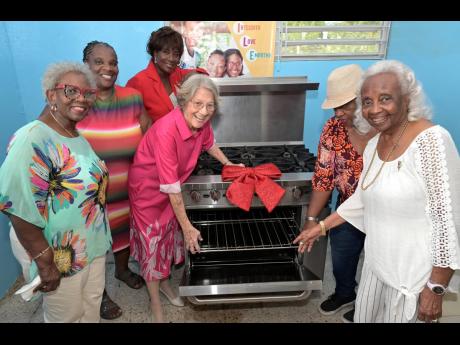 Racquel Ellis (third left), administrative and facilities manager of the YWCA, and her students welcome gifts from Dr Barbara Matalon (fourth left), president of the Canadian Women’s Club of Jamaica (CWC);  Joan McDonald (right), vice- president and coo