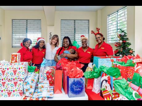 Tami Chin-Mitchell (third left) and the Fontana marketing team share in a photo op with Nadia Williams (centre), manager at the Mary’s Child home.