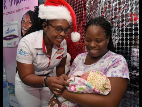 Marlene Wright (left), merchandiser at Cari-Med Group, fusses over baby Alara Williams, held by her mother Sashenee Williams (right), when the Cari-Med team visited the Victoria Jubilee Hospital on New Year’s Day. The Cari-Med team visited the hospital b