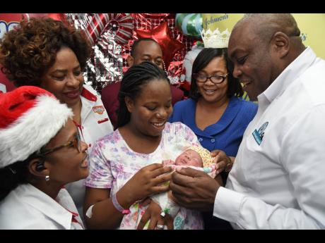 Sashenee Williams (third right) holds Alara Williams, the first baby to be born at the Victoria Jubilee Hospital (VJH) for 2025. Looking on are, from left, Merlene Wright, merchandiser, Carimed Group; Edith Khan, health educator, coordinator, Carimed Group
