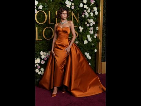 Credit: AP Serving old Hollywood glamour, Zendaya arrives in a Louis Vuitton copper satin dress and a shiny ring.