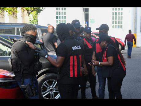 Credit: Antoine Lodge/Photographer Members of a team from the Major Organised Crime & Anti-Corruption Agency outside of the St Catherine Municipal Corporation’s offices in Spanish Town, St Catherine, on Thursday amid a massive 17-location operation linked to a fraud investigation.