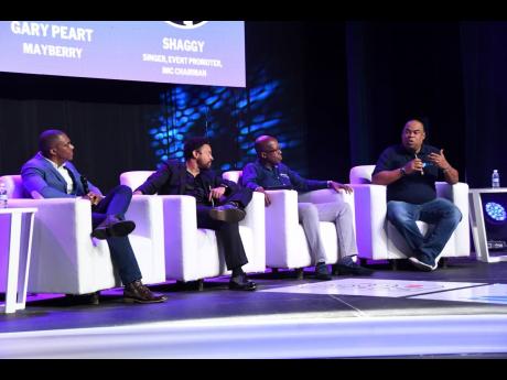 Credit: File Seen here at the inaugural Island Music Conference is panellist and Mayberry Investments Limited CEO Gary Peart at right, giving pointers during the session on money management, investment, and insurance for musicians at the Courtleigh Auditorium in New K