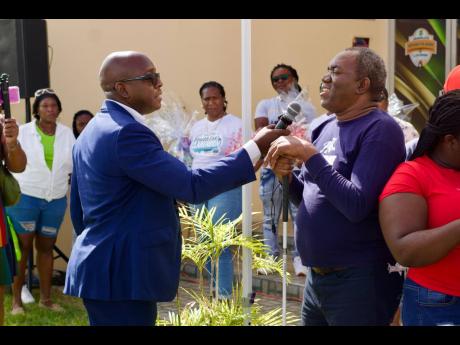 Member of Parliament of South East Clarendon Pearnel Charles engages a blind participant at the Joyful Hearts Outreach Initiative in Clarendon recently. 