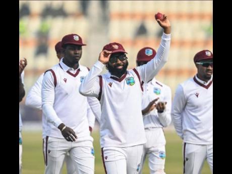 West Indies’ Jomel Warrican (centre) raises the game ball after his figures of 7-32 in the second innings of the first Test against Pakistan at the Multan Cricket Stadium on January 19.