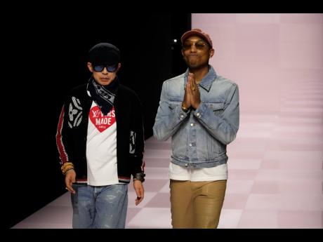 Pharrell Williams (right) walks alongside Nigo, artistic director for Kenzo and co-creator of their collection.