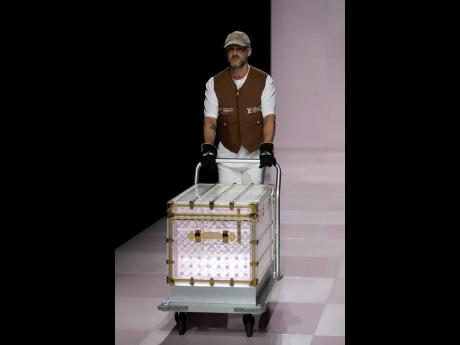 A man presents a suitcase as part of the men’s Louis Vuitton Fall-Winter 2025-2026 collection.
