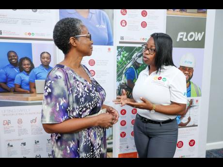 Credit: Contributed Alesha Anderson (right), Flow’s associate manager, safety and liability, in discussion with Karleen Black, education and information officer at The University of the West Indies Earthquake Unit.