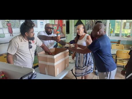 Residents at the Portland Rehabilitation Centre served warm meals by (from left) Telief Hall and Aubyn Hall of Roots 21 fine dining restaurant and Carla Gullota,  principal director of the Portland Rehabilitation Centre. 