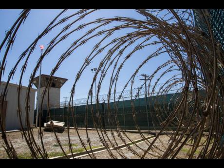 FILE - In this April 17, 2019, photo, reviewed by US military officials, the control tower is seen through the razor wire inside the Camp VI detention facility in Guantanamo Bay Naval Base, Cuba. (AP Photo/Alex Brandon, File)