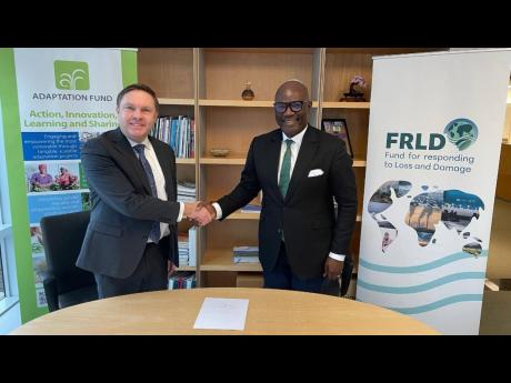 Mikko Ollikainen (left), head of the Adaptation Fund, greets Ibrahima Cheikh Diong, executive director of the Fund for responding to Loss and Damage.