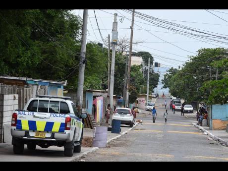 Credit: File In this September 30, 2021 photo, police keep a watchful eye on Fourth Street in Trench Town, St Andrew, after an upsurge in gang violence that resulted in two women being killed.