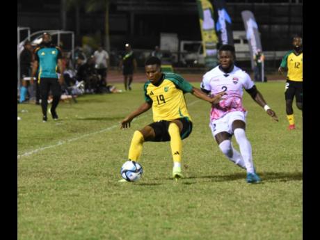Jamaica’s Christopher Ainsworth (left) shields the ball from Trinidad & Tobago’s Isaiah Garcia during their international friendly match at the Montego Bay Sports Complex on Thursday night.