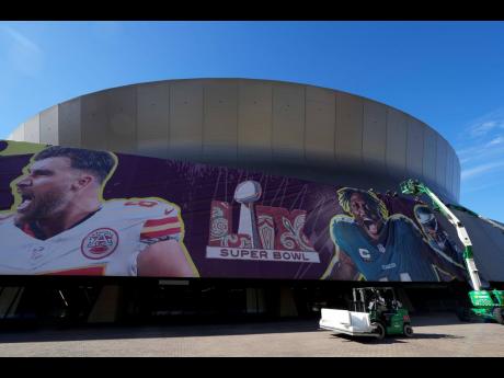 Workers hang player banners outside the Caesars Superdome, on Saturday, February 1, 2025, in New Orleans, prior to the NFL Super Bowl 59 football game between the Philadelphia Eagles and the Kansas City Chiefs.