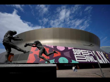 
People walk outside the Caesars Superdome on January 31, 2025, in New Orleans prior to the NFL Super Bowl 59 football game between the Philadelphia Eagles and the Kansas City Chiefs.
