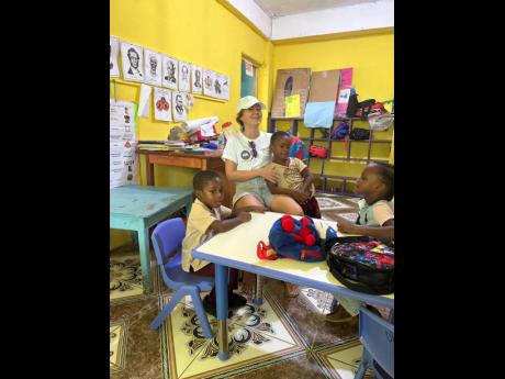 Melissa Terry, group foundation manager at Chukka, hangs out with students in one of the newly refurbished classrooms at the Dalmally Basic School in Dias, Hanover. The extensive infrastructural and educational improvements at the school were made possible