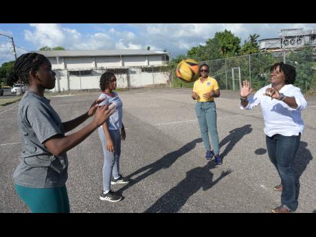 Fiolina Lovell-Burnett (right) throws the ball to Jada Wallace (left), a student of the St Hugh’s High School for Girls, while practising on the school’s netball court on Friday. Sharing in the session are Kenya Graham (second right) and Latoyia Hinds-