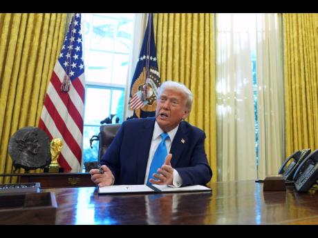 President Donald Trump speaks to reporters as he signs executive orders in the White House.