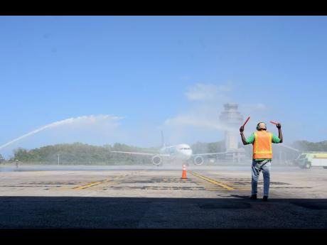 In this February 24, 2023 file photo, a plane is welcomed with jet streams on its inaugural flight into Sangster International Airport in Montego Bay.