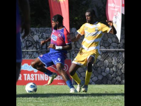 Duneholden’s Dean Andre Thomas (left), the lone goalscorer in a Jamaica Premier League match against Molynes United at the Anthony Spaulding Sports Complex yesterday, moves away from Stevaughn Johnson.  
