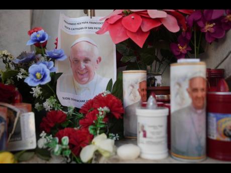 Candles and a photo of Pope Francis are seen in front of the Agostino Gemelli Polyclinic, in Rome on February 22, 2025, where the Pontiff is hospitalised since February 14.