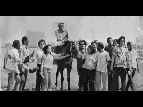 
In this 1973 file photo, George HoSang, aboard King Pin, is surrounded by a throng of jubilant supporters.