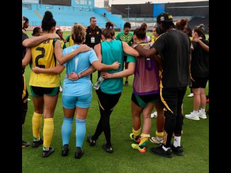 Credit: Courtesy of @jff_football Reggae Girlz coach Hubert Busby takes his charges through a final team talk before their first friendly against Peru on Sunday.
