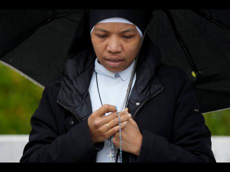 A nun prays for Pope Francis in front of the Agostino Gemelli Polyclinic, in Rome, on Saturday.