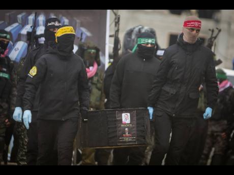 Credit: AP Palestinian militants carry a coffin containing the body of Kfir Bibas as the remains of four bodies are handed over to the Red Cross in Khan Younis, southern Gaza Strip. Israel identified three of the bodies as hostages and said the other was of an unknow