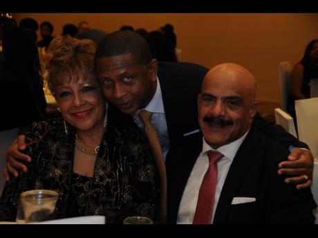 Gary Williams (centre) embraces longstanding contributors to COJO, Leslie Hall (left) and Michael Hall in 2018.